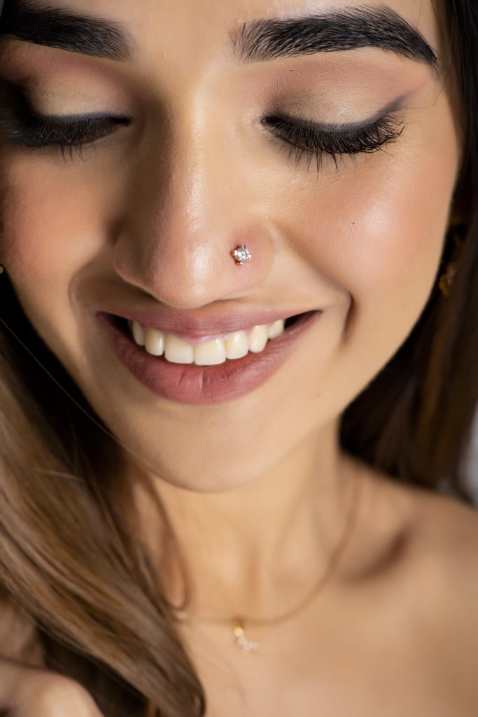 Woman wearing a sparkling solitaire stud nose pin from KuberBox)